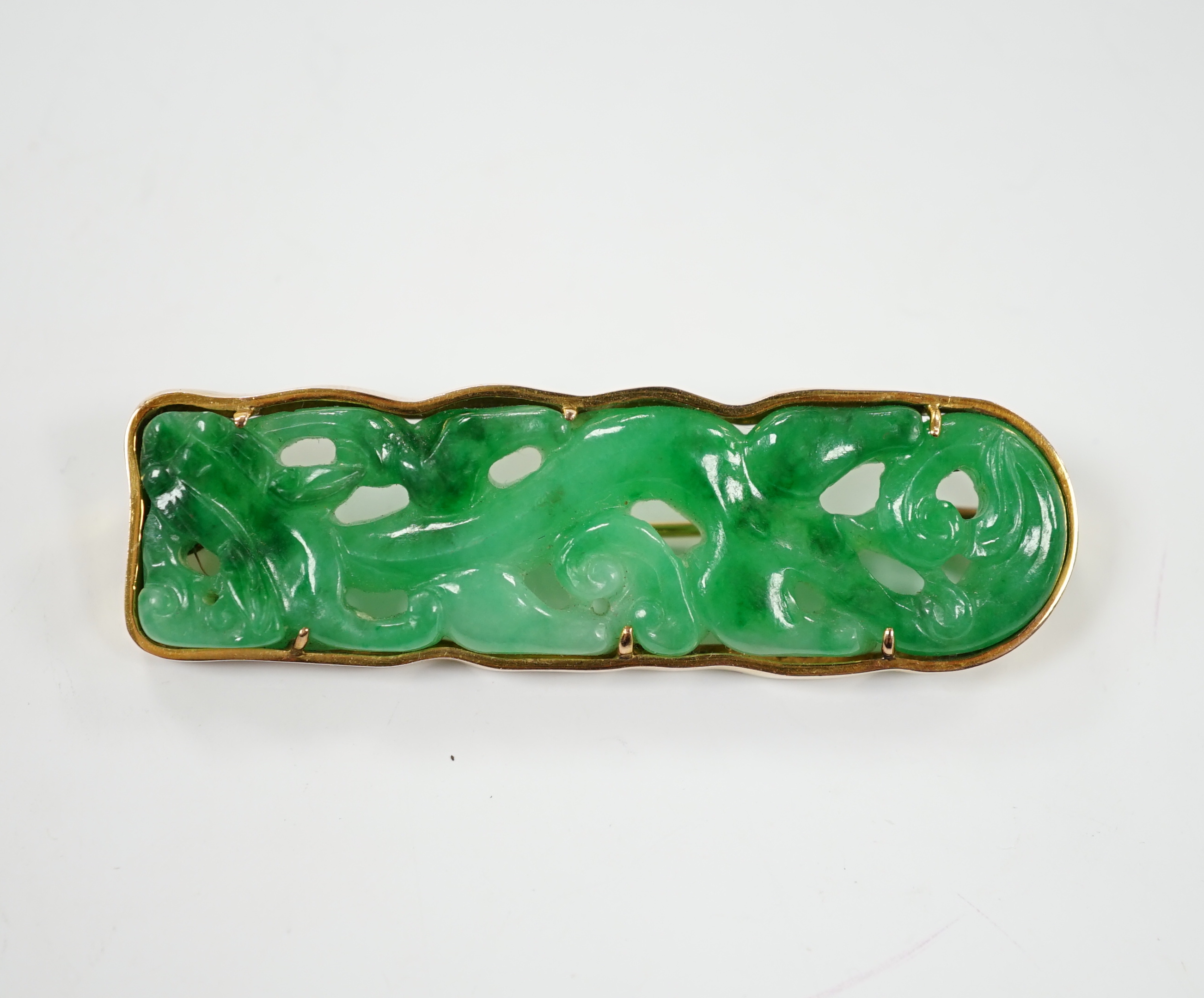 A Chinese 14k yellow metal and carved jade set rounded rectangular brooch, 63mm